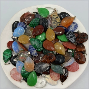 Mix of teardrop faceted crystal and agate stone pendants for jewelry making on white tray