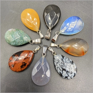 Macro shot of 8 faceted teardrop crystal and agate stone pendants for DIY necklaces