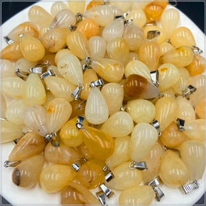 Bulk display of teardrop natural agate pendants with silver metal bails on a tray