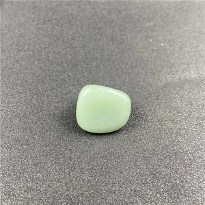 Close-up of polished light green crystal stone with smooth texture and natural patterns
