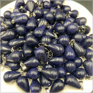 Pile of blue goldstone teardrop pendants with sparkling galaxy texture and silver clips