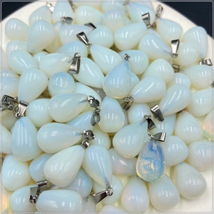 Close-up of bulk teardrop white opalite crystal pendants with silver metal clasps