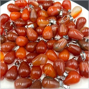 Macro view of natural carnelian agate teardrop pendants with polished silver clasps
