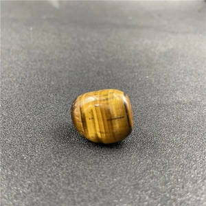 Macro shot of polished yellow tiger eye stone showing smooth surface and silky luster