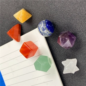 Detailed set of seven natural chakra crystals in various geometric shapes on a dark surface