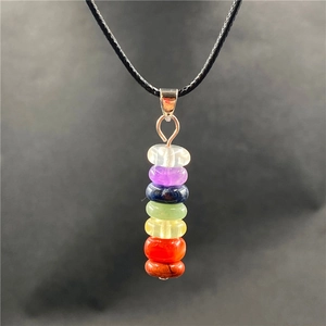 Macro shot of seven chakra natural crystal healing stones with black cord necklace