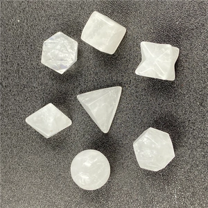 Detailed view of 7-piece white crystal geometric solids including Merkaba on dark background