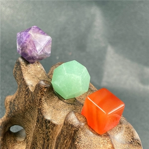 Detailed view of geometric crystal stone ornaments on a dark textured display stand