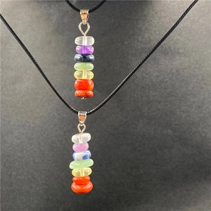 Detailed view of the seven chakra natural stones stacked on a black necklace cord