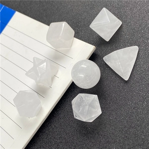 Macro shot of 7 white geometric crystal ornaments on a notebook for teaching display