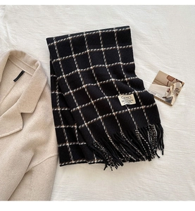 Detail of checkered cashmere shawl with tassel hem and minimalist brand label