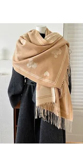 Detail van de camel kasjmier-gevoel sjaal met teddybeer jacquard patroon en lange franjes