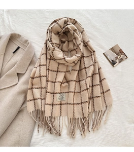 Detail of beige plaid scarf with soft fringe edges and ZIAN brand label on fabric