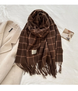 Detailed view of dark brown plaid scarf with tassels and soft cashmere-like texture