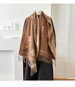 Détail d'une écharpe en jacquard épais avec motifs ours, cœurs et franges longues