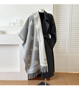 Détail du motif ours et cœur jacquard double face avec pompons sur un châle élégant