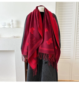 Détails du motif jacquard ours et cœur sur un châle doux en cachemire avec franges