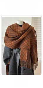 Detail of double-sided jacquard scarf with brown and orange geometric plaid and tassels