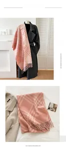 Detail of pink plaid imitation cashmere scarf with tassels and soft fabric texture
