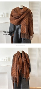 Detail of double-sided plaid cashmere-like scarf with long fringe displayed on grey coat