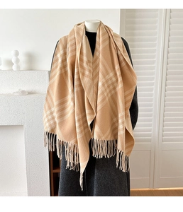 Close-up of beige plaid cashmere-feel scarf with elegant fringe detail and soft texture