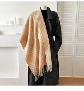 Detailed view of beige cashmere plaid shawl with fringe on a gray wool coat