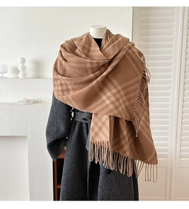 Detailed view of the plaid texture and tassels on this brown faux cashmere scarf