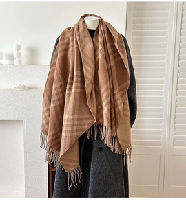 Detail of soft brown plaid cashmere scarf with long tassels on a grey wool coat