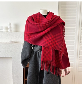 Detail of red plaid cashmere-feel scarf with fringes on a mannequin with wool coat
