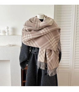 Detail of earthy plaid cashmere-like scarf with long fringe and soft woven texture