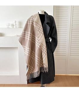 Detail of soft checkered scarf with fringe tassels on a minimalist elegant mannequin