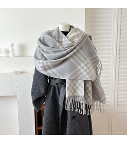 Detailed close-up of thick plaid scarf texture with soft fringes and cashmere-like fabric