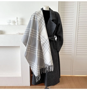 Detail view of the soft plaid cashmere-feel scarf with long fringe and warm texture