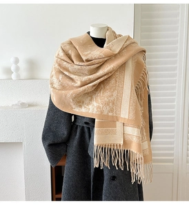 Detail of camel jacquard shawl featuring vintage white patterns and fringe tassels