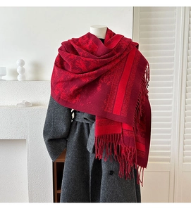 Detailed view of red retro jacquard scarf with fringe on a gray tweed coat