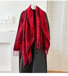 Close-up of vintage floral red jacquard scarf with tassels on a grey winter coat