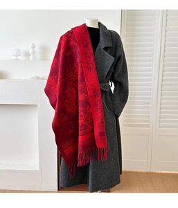 Detail of red jacquard scarf with retro floral pattern and long fringe on wool coat