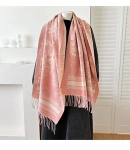 Detail of pink jacquard knit scarf showing elegant fringe and soft texture on model
