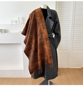 Detail of vintage jacquard scarf with tassels on grey coat in a minimal interior
