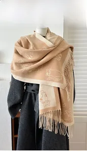 Detail of cute cat jacquard pattern and long fringe on beige winter cashmere scarf