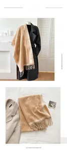 Detail of soft cashmere-like scarf showing cute white cat pattern and long fringe trim