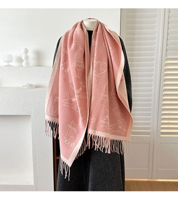 Close-up of pink and white cat jacquard knit scarf with thick tassels and soft texture