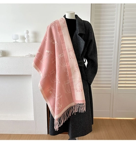Pink cashmere-feel scarf with white cat patterns and tassels on a grey wool coat