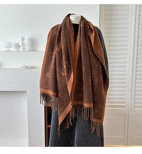 Detail of caramel cashmere-like scarf showing cute cat jacquard and soft long tassels