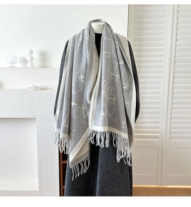 Detail of light grey scarf with white cat jacquard and fringes on a mannequin