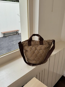 Detailaufnahme der braunen Stepp-Tragetasche aus Nylon mit gewellter Steppung und Gurt