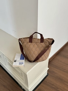 Nahaufnahme der khakifarbenen Stepptasche mit braunen Griffen und Wellensteppmuster