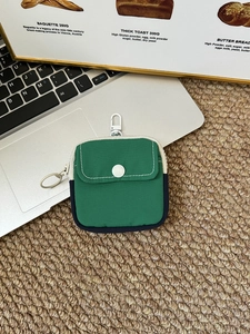 Detailed view of mini green storage pouch with front snap pocket and hanging hook accessory