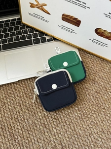 Detail of navy and green mini storage pouches with button pockets and metal hooks
