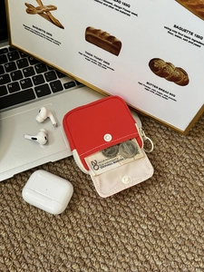 Detail of red and beige canvas mini pouch with snap button for coins and bills